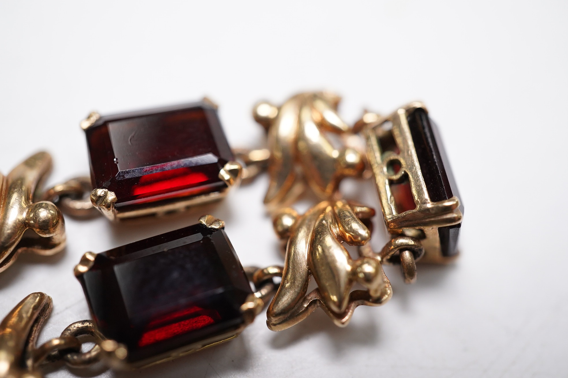 A yellow metal and nine stone emerald cut garnet? set bracelet, 18cm, gross weight 16.5 grams. Condition - fair